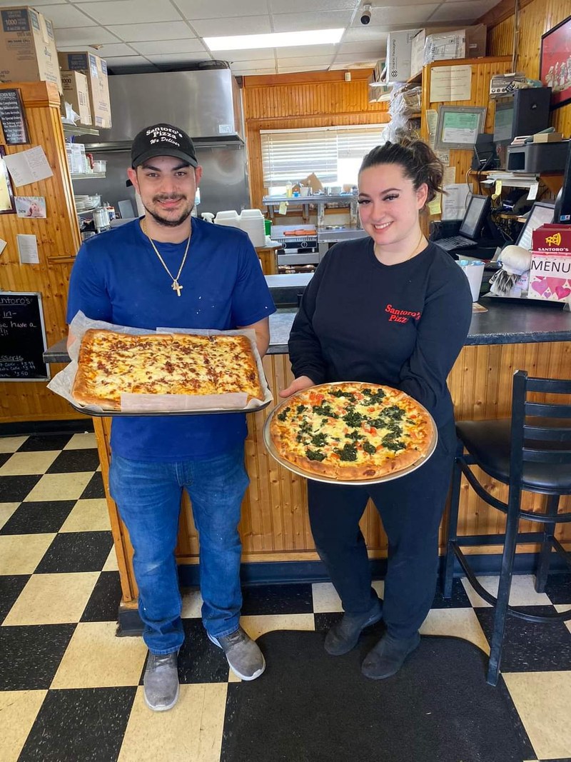Nicholas Labrakis holds a sheet pizza beside his sister Deanna with a spinach-and-feta Deanna&rsquo;s Pizza, inside Santoro&rsquo;s Pizza, Coventry.